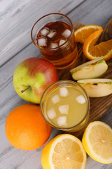 glasses of juice with fresh fruits on grey wooden table