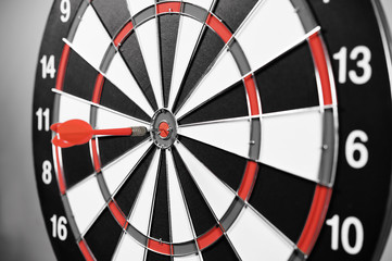 Dartboard with red darts on gray background.