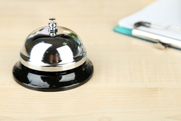 Reception bell on hotel reception desk, on bright background