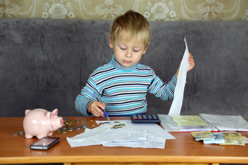 little boy is engaged in home accounting