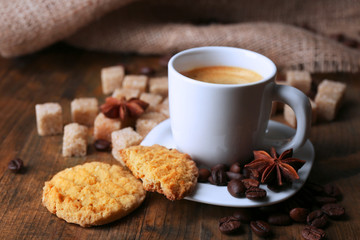 Cup of espresso and tasty cookie on wooden background