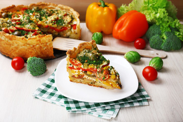 Fototapeta na wymiar Piece of Vegetable pie with broccoli, peas, tomatoes and cheese
