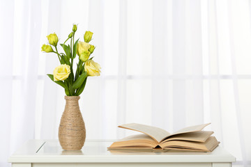 Beautiful bouquet of flowers in vase on window background