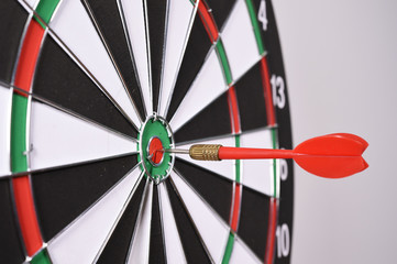 Dartboard with red darts on gray background.