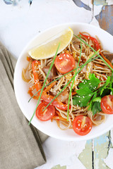 Chinese noodles with vegetables and roasted meat in bowl