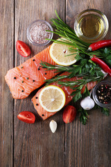 Fresh salmon with spices and lemon on wooden table