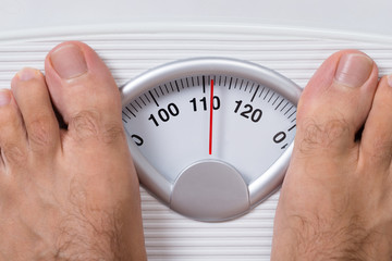 Man's Feet On Weight Scale