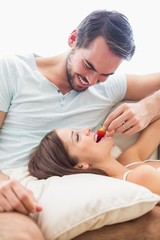 Obraz na płótnie Canvas Man feeding his girlfriend a strawberry
