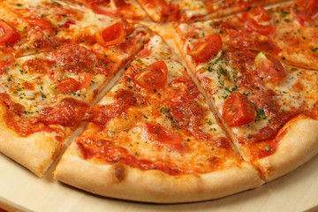 Delicious pizza on wooden plate