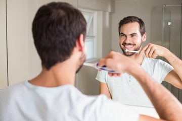 Fototapeta premium Young man brushing his teeth