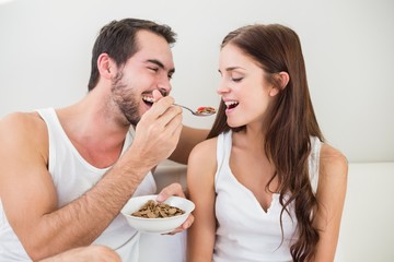 Young couple having breakfast in bed
