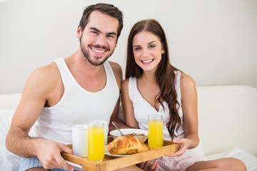 Young couple having breakfast in bed