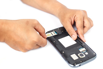 Hand holding sim card and put into smartphone isolated on white