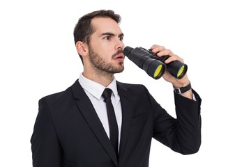 Surprised businessman standing and holding binoculars