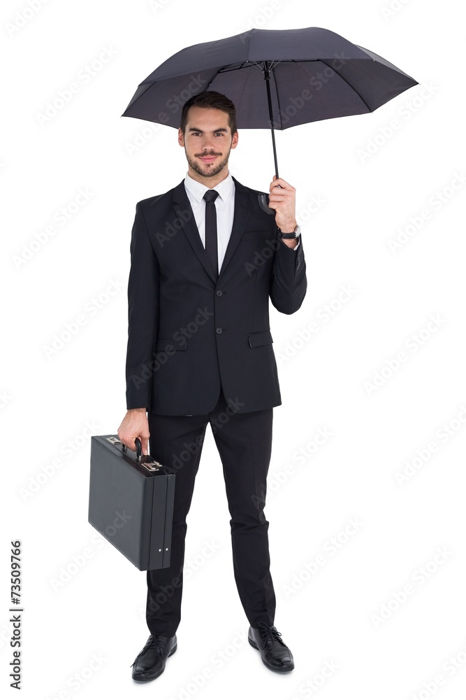 Aufkleber smiling businessman under umbrella while holding briefcase