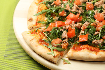Delicious pizza on a wooden plate
