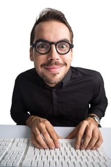 Excited businessman with glasses typing on keyboard