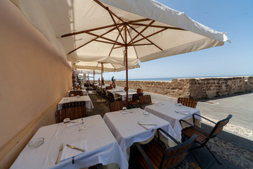 Reastaurant tables and chairs outside stone building in Sardinia