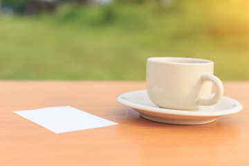 Close up coffee cup and paper note on the table in the morning