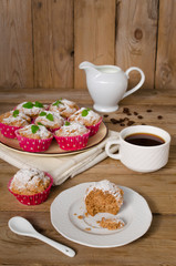 Muffins with coffee on wooden background