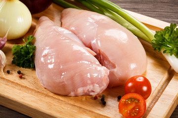 Raw chicken breasts on cutting board