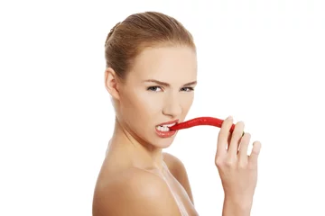 Foto auf Acrylglas Portrait of nude woman biting a chilli pepper © Piotr Marcinski