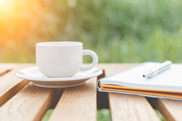A cup of coffee on the table and notebook