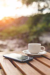A cup of coffee and smartphone on the table