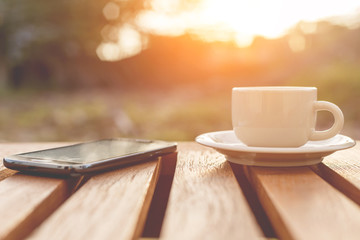 A cup of coffee and smartphone on the table