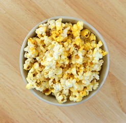 Bowl full of popcorn on wood tabletop
