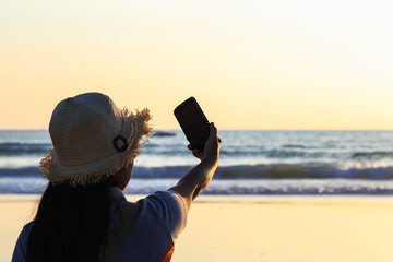 Thai Woman using smartphone at the beach