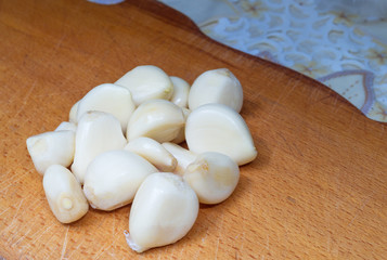 Garlic on the board on the table in the kitchen