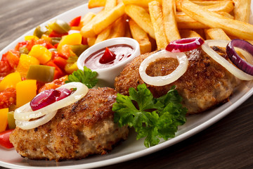 Fried chops, French fries and vegetable salad