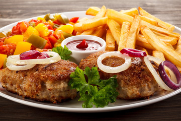 Fried chops, French fries and vegetable salad