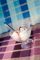 Glass bowl of icecream with raspberry topping
