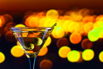 glass with martini and green olives