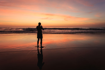 Fototapeta na wymiar Silhouette of tourist at sunset beach in Phuket Thailand