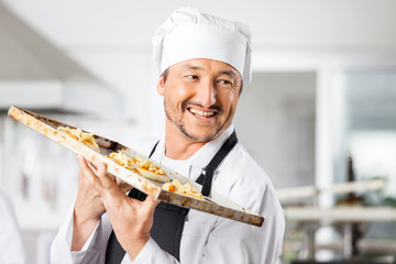 Happy Chef Holding Small Pizzas On Baking Sheet