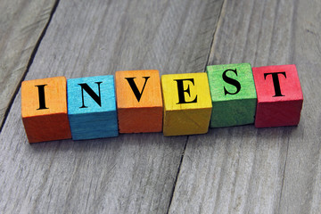 concept of invest word on wooden colorful cubes