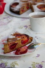 A piece of plum pie on a plate on the festive table.