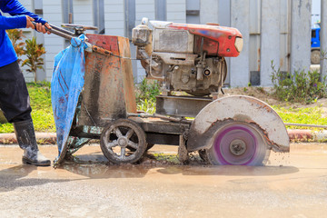 Road workers cutting asphalt road