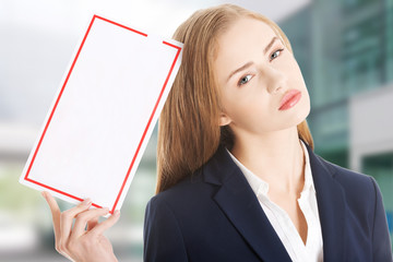 Beautiful caucasian business woman is holding empty white board.