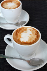 Cup of hot cappuccino on the black background