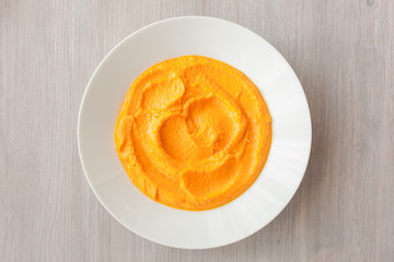 Pumpkin cream-soup with seeds in a white plate