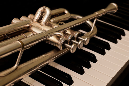 Detail of trumpet lying on the piano keys