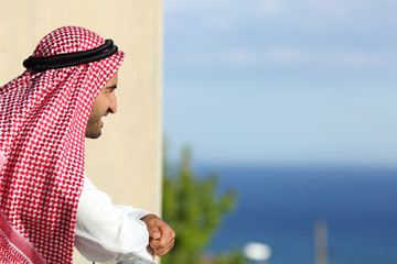 Arab saudi man looking the sea from a balcony of an hotel