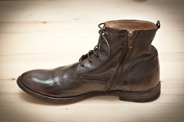 Fashionable leather brown shoes on a wooden surface