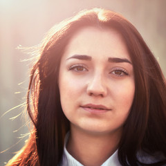 Portrait of a young pretty girl in a light shirt and with her ha