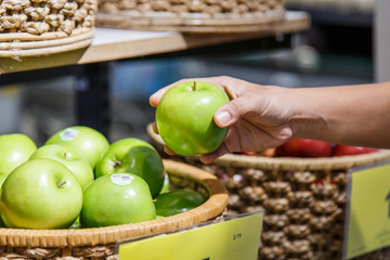 Hand holding apple in department store