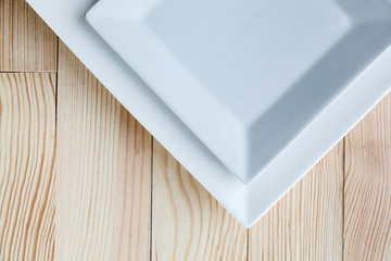 Square white plates over wooden table